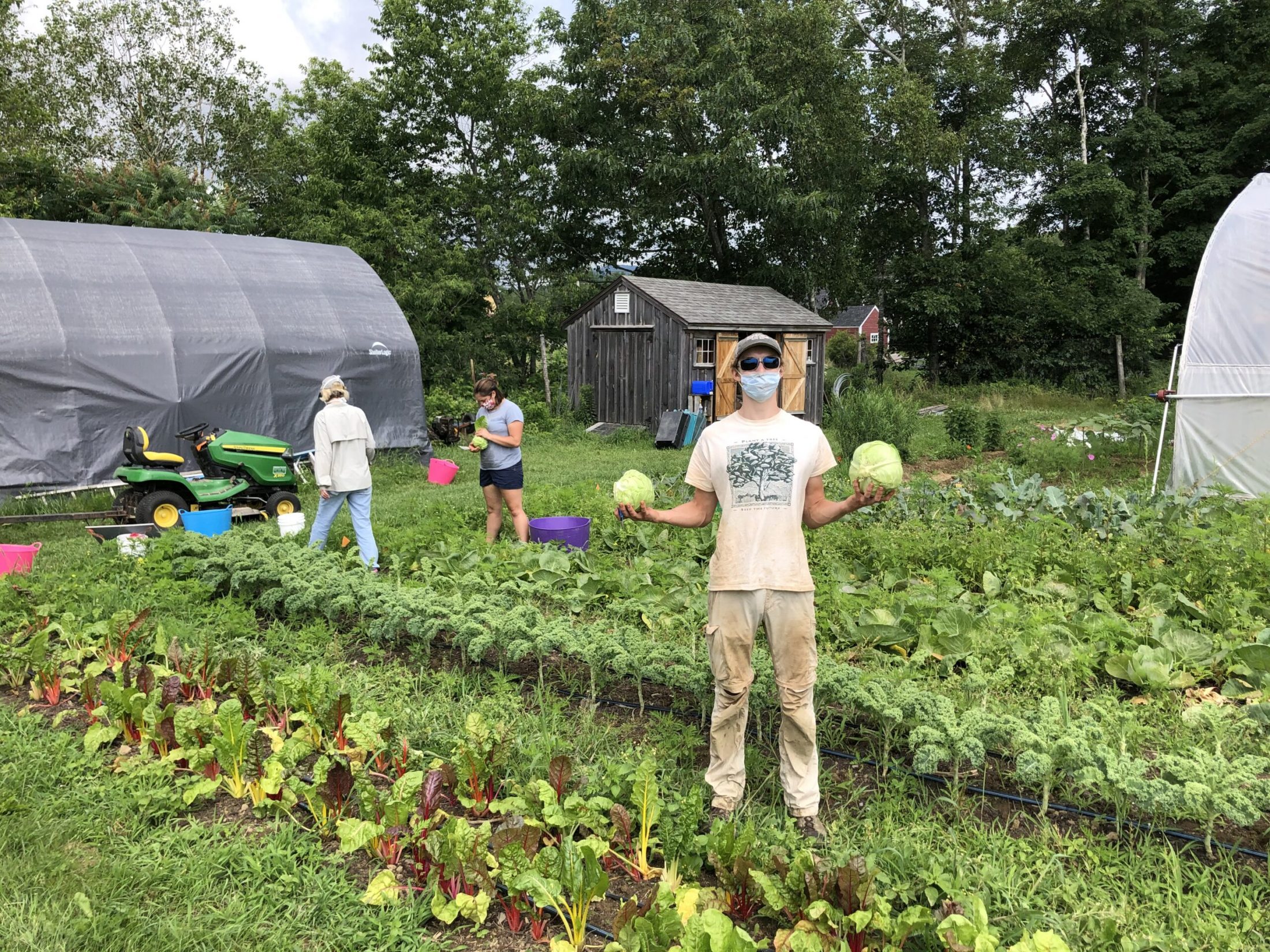 Teen Ag Crew Leader, Charlie Cooper, holds head of cabbage harvested at Erickson Fields.